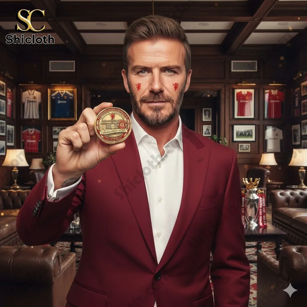 A man in a red suit holding a Manchester United commemorative coin in a classic club room.