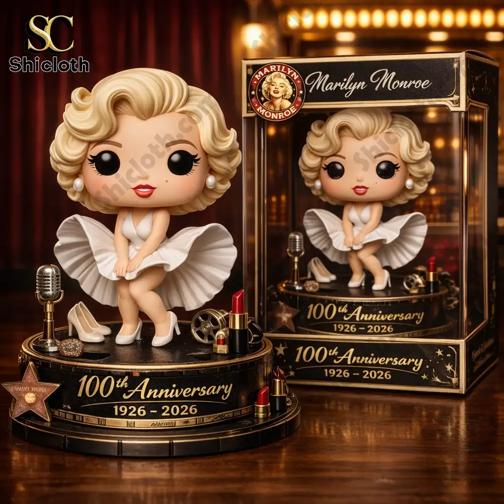 A boxed collectible figure of a blonde woman in a white dress celebrating the 100th anniversary 1926–2026 displayed on a table.