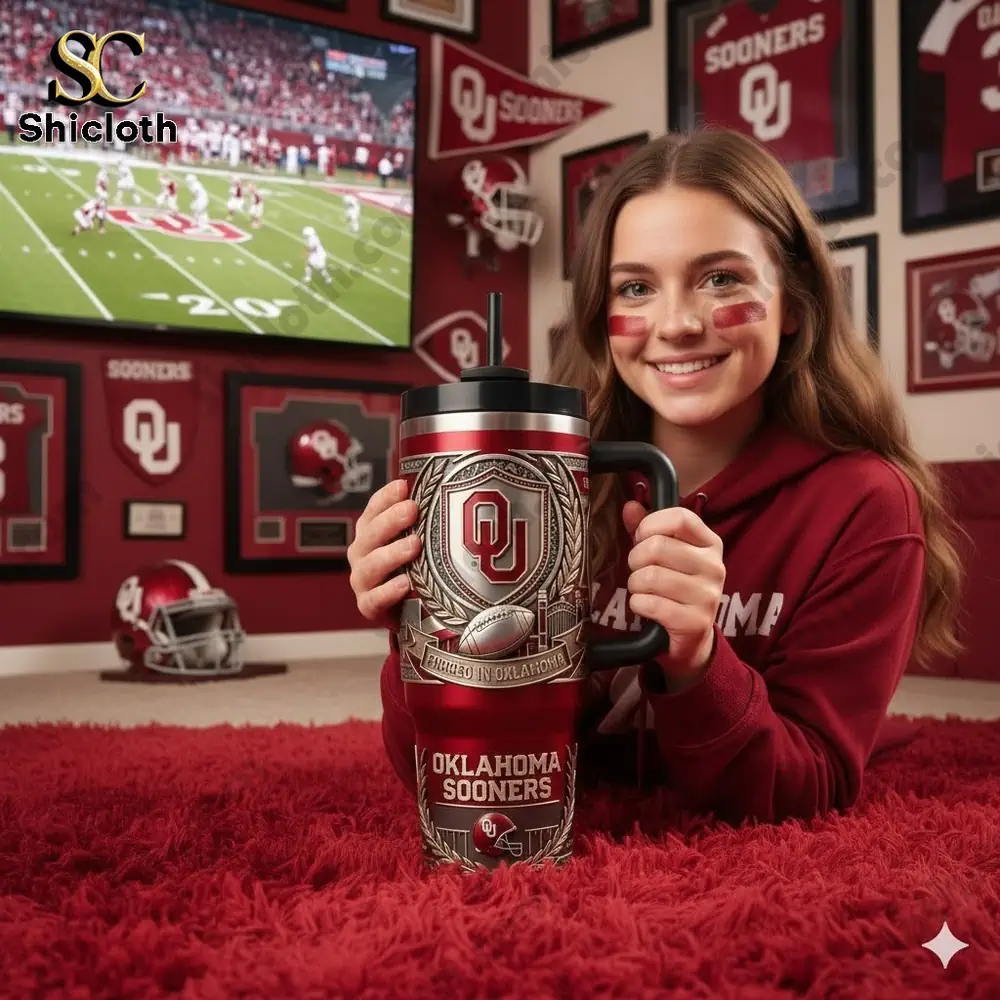 Young fan holding Oklahoma Sooners tumbler while watching football game!