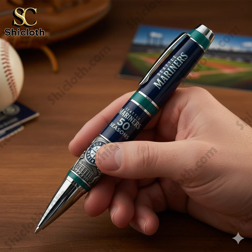 A hand holding a Seattle Mariners Fifty Seasons commemorative pen on a wooden desk!
