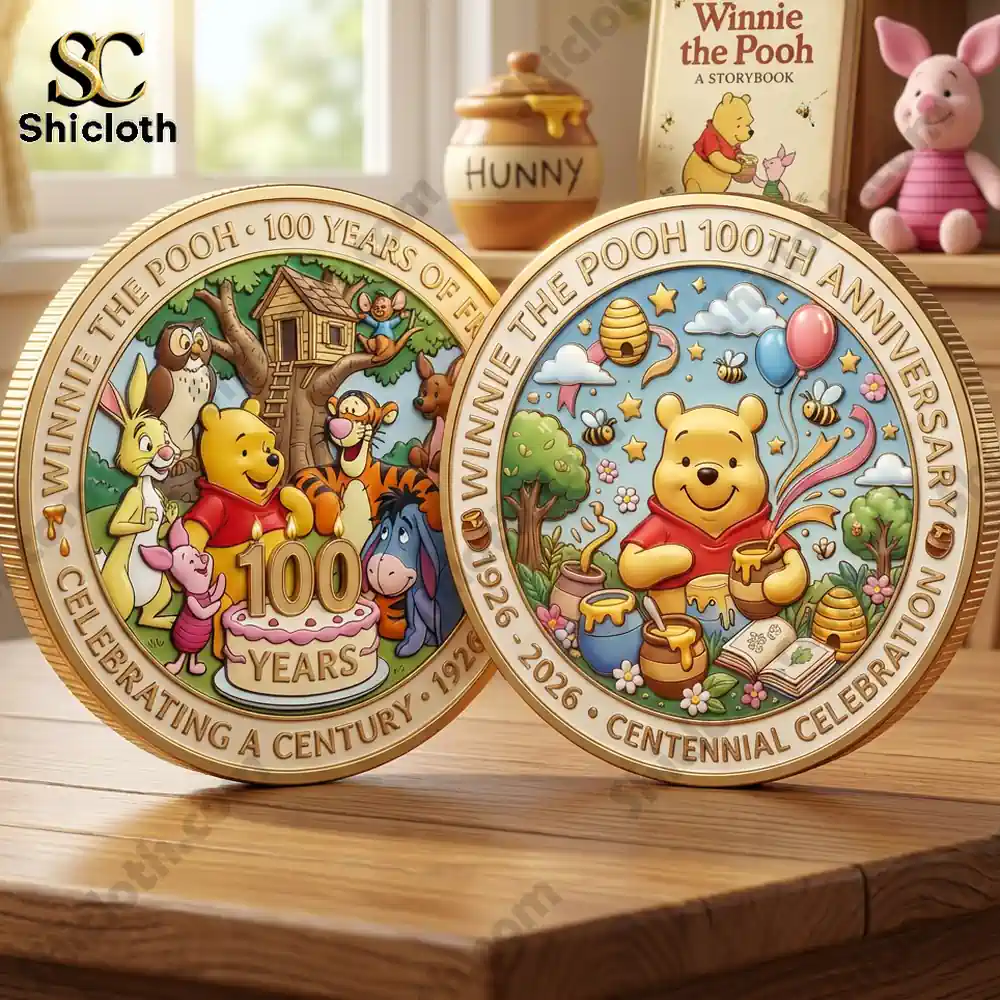 Two Winnie the Pooh centennial coins displayed on a wooden table!