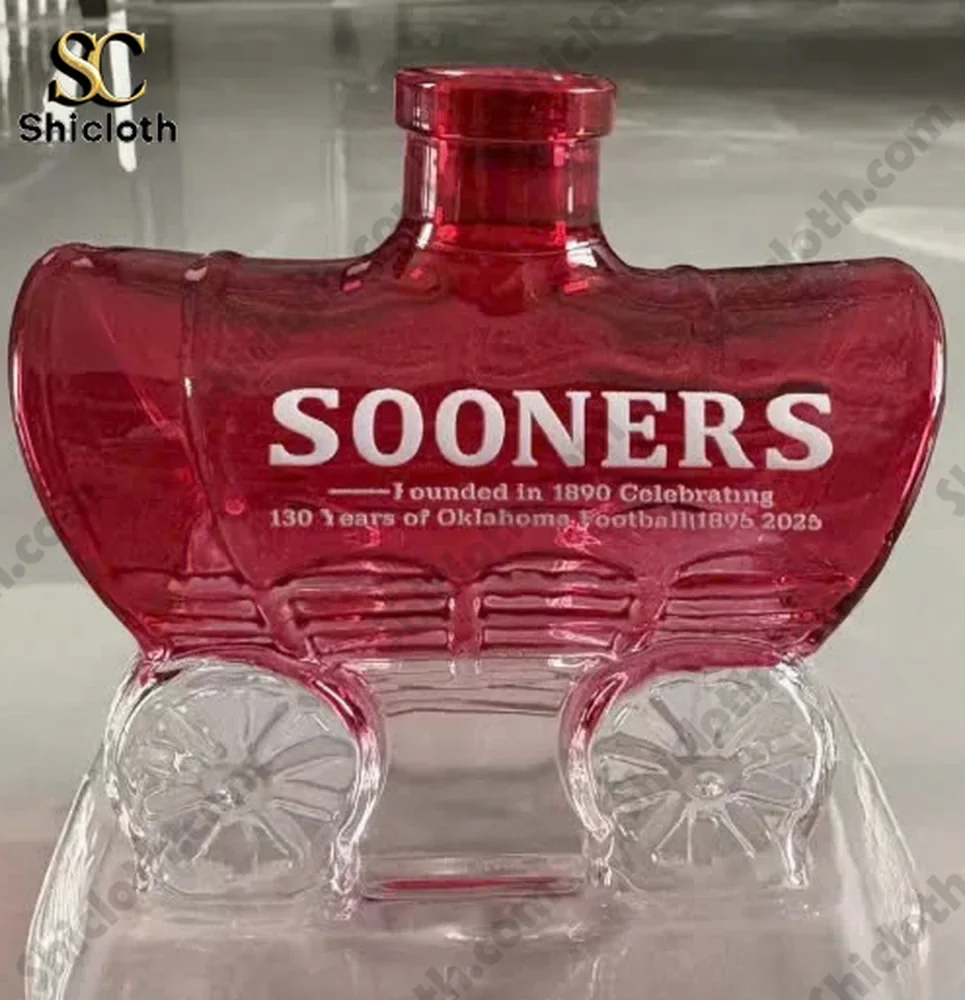 Close up of red Sooners wagon shaped glass bottle