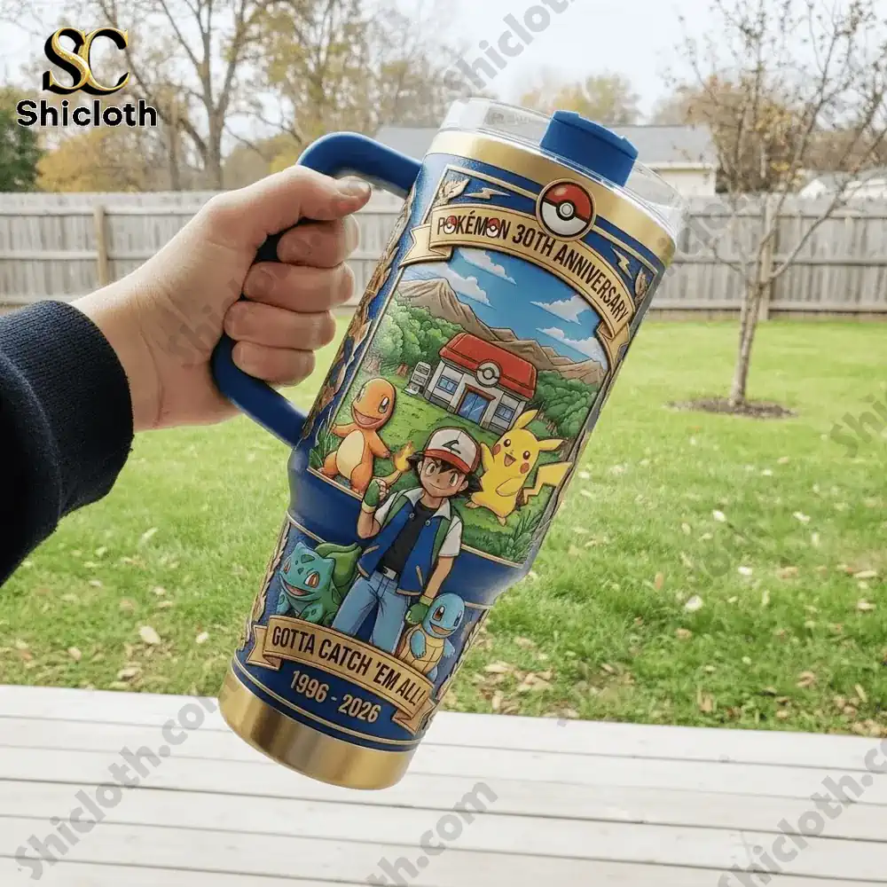 Hand holding a Pokemon 30th Anniversary tumbler outdoors in a backyard.