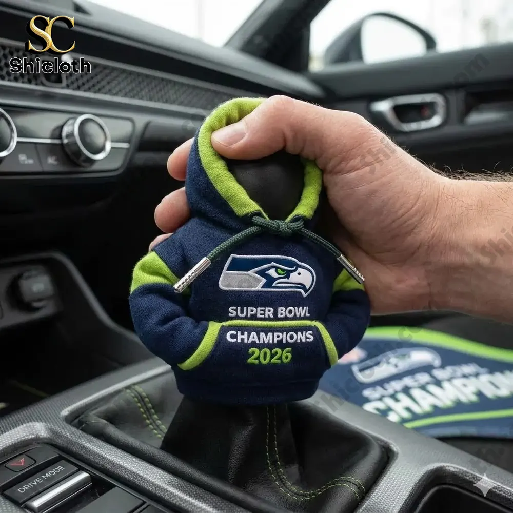 Hand holding Seattle Seahawks Super Bowl 2026 Champions gear shift hoodie inside a car