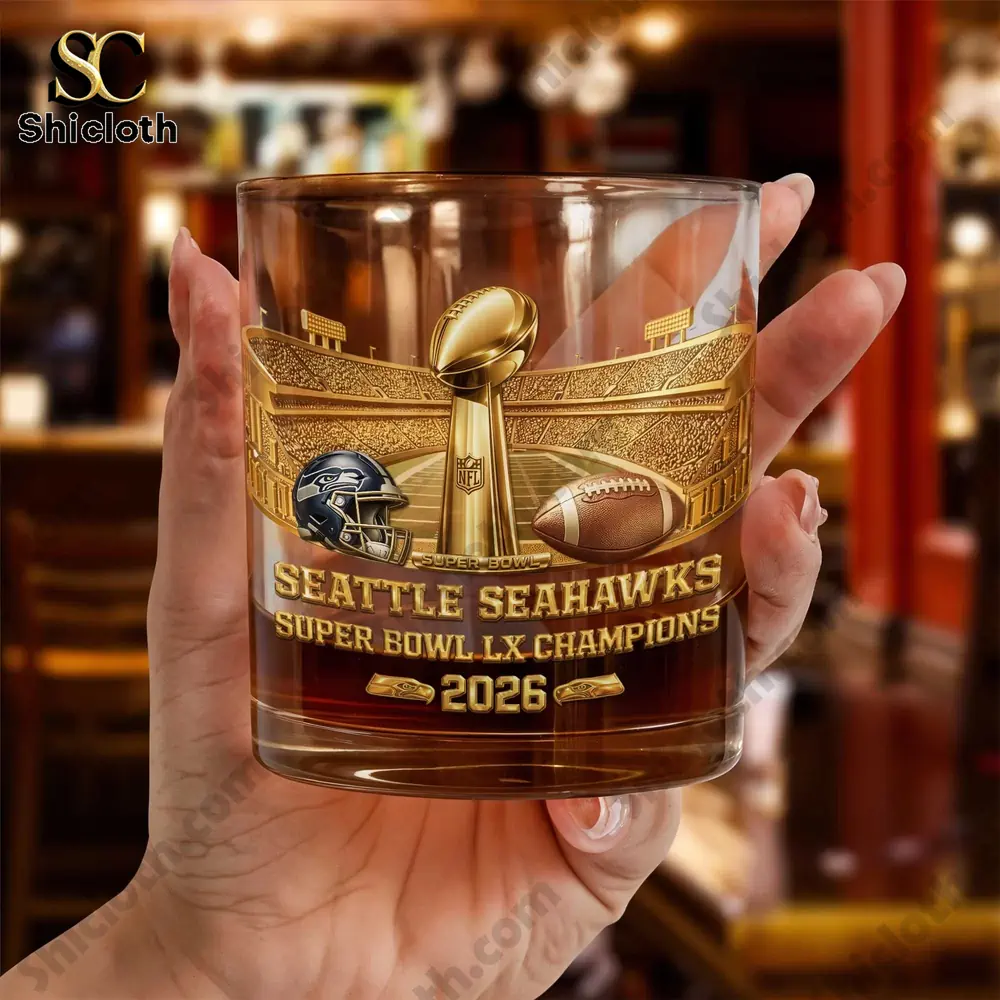 Seattle Seahawks Super Bowl LX Champions 2026 Whiskey Glass 4 Hand holding a Seattle Seahawks Super Bowl LX Champions 2026 whiskey glass in a bar setting.