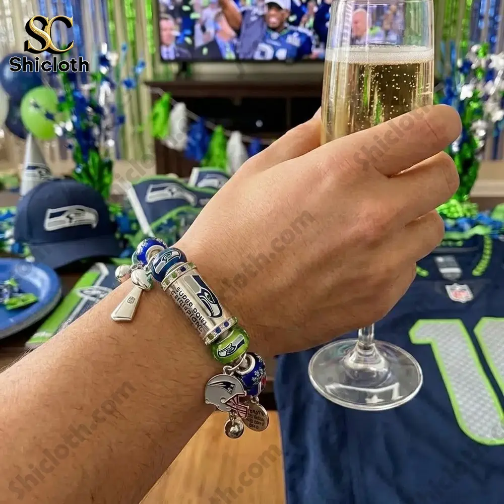 Hand wearing a Seattle Seahawks Super Bowl 60 Champions bracelet while holding a champagne glass at a party!