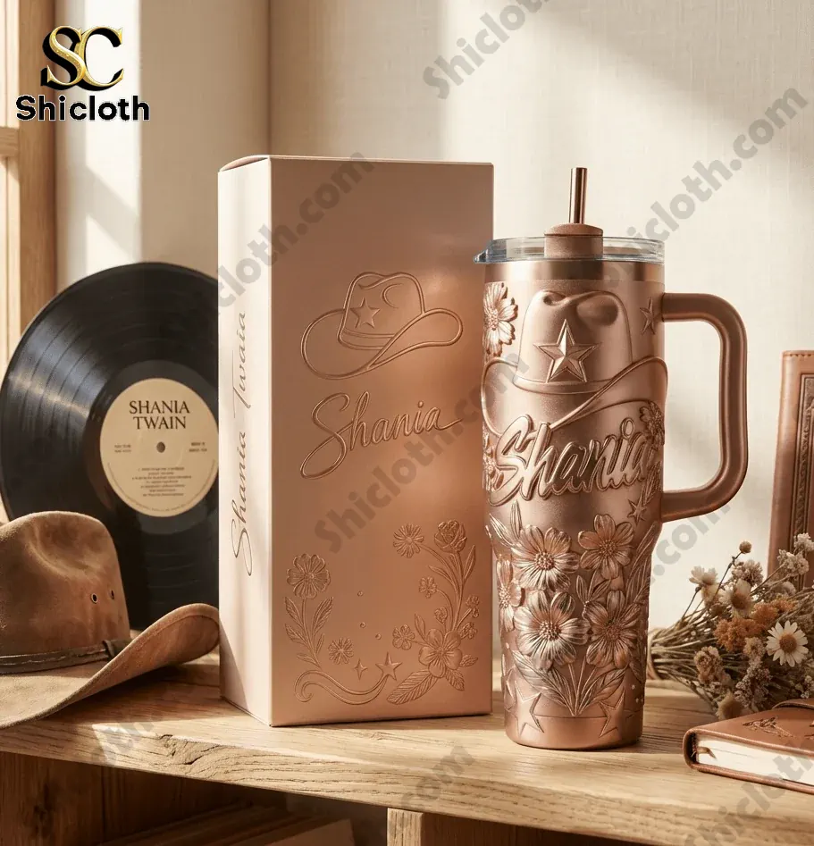 Rose gold Shania Twain tumbler with handle next to gift box and vinyl record