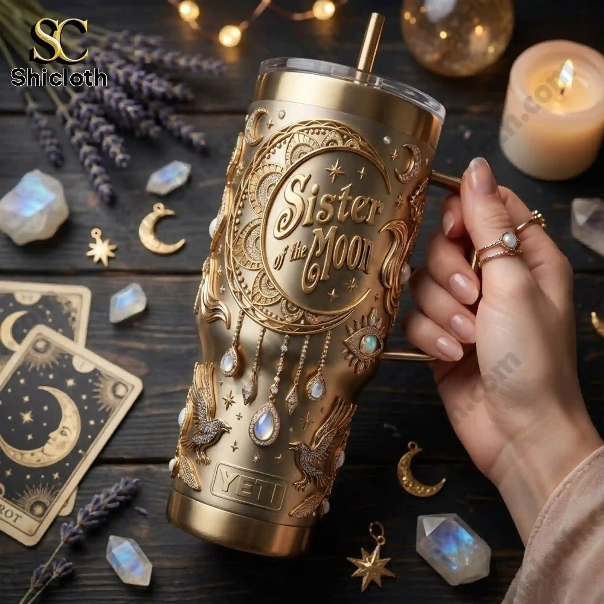 Sister of the Moon Celestial Gold Goddess 40oz Tumbler With Handle 4 Hand holding a Sister of the Moon gold tumbler surrounded by tarot cards crystals and candles!