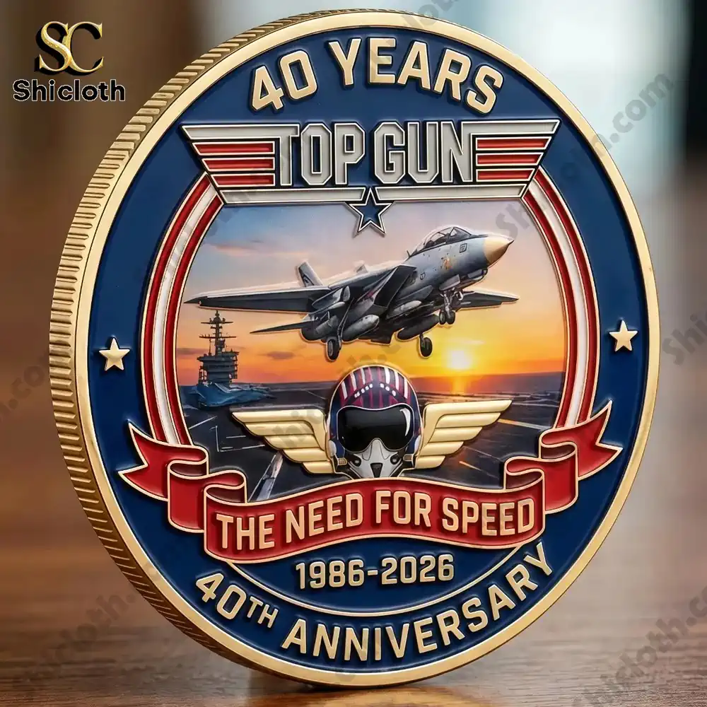 Top Gun 40th anniversary commemorative coin with jet and aircraft carrier at sunset.