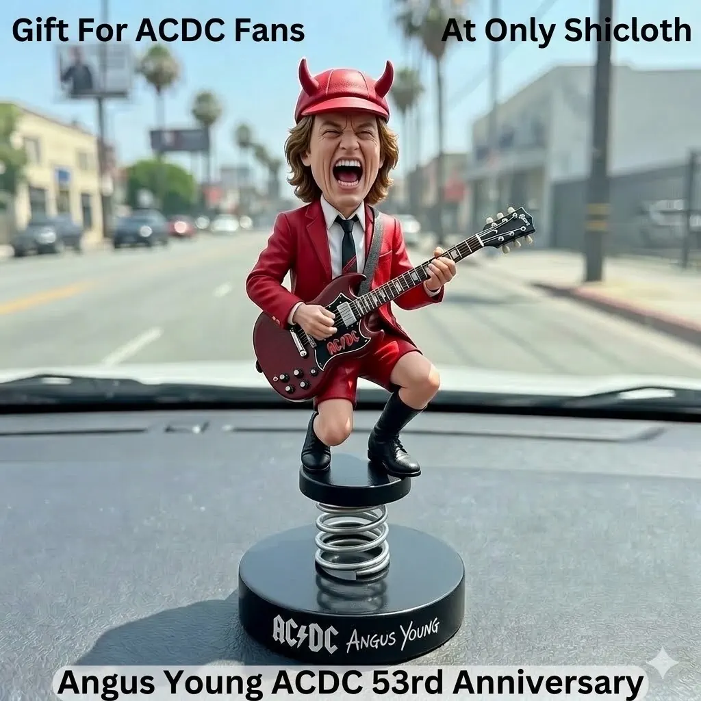 Angus Young ACDC anniversary car dashboard bobblehead figure rocking with guitar on spring base inside a car.