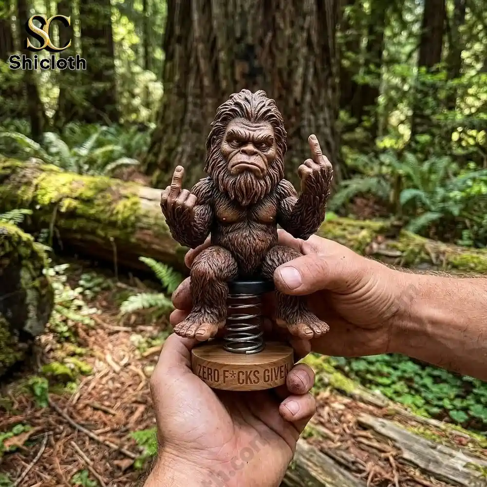Bigfoot dashboard bobblehead statue showing middle fingers held in hands in forest setting!