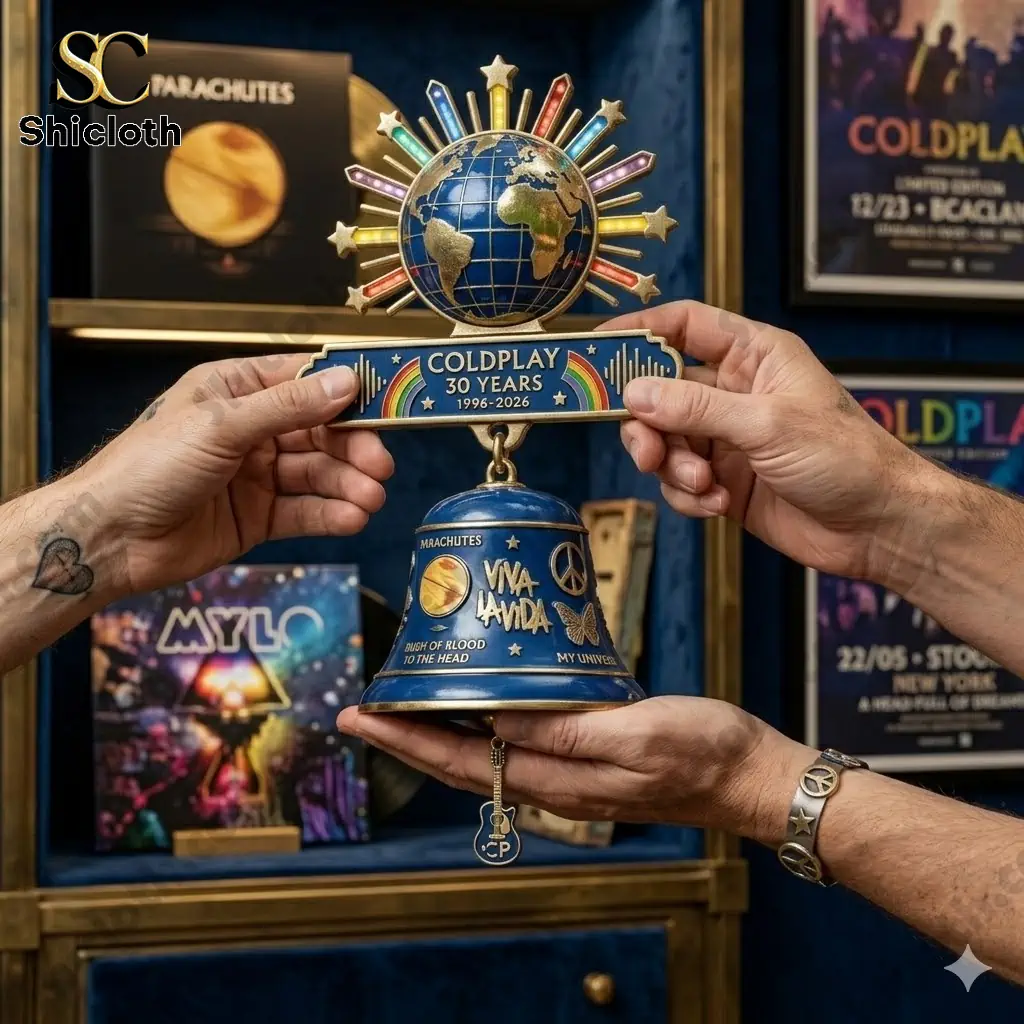 Hands holding Coldplay 30 Years commemorative wall bell with globe and blue bell design