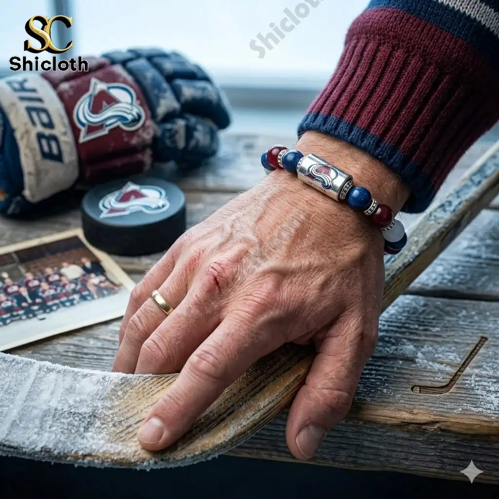 Colorado Avalanche bracelet on man wrist holding ice hockey stick on snowy bench!