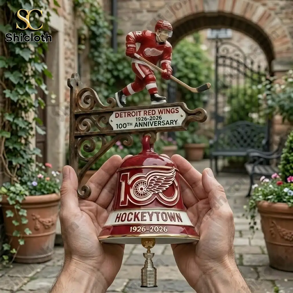 Detroit Red Wings HockeyTown 100th Anniversary commemorative bell held in hands in a garden courtyard!