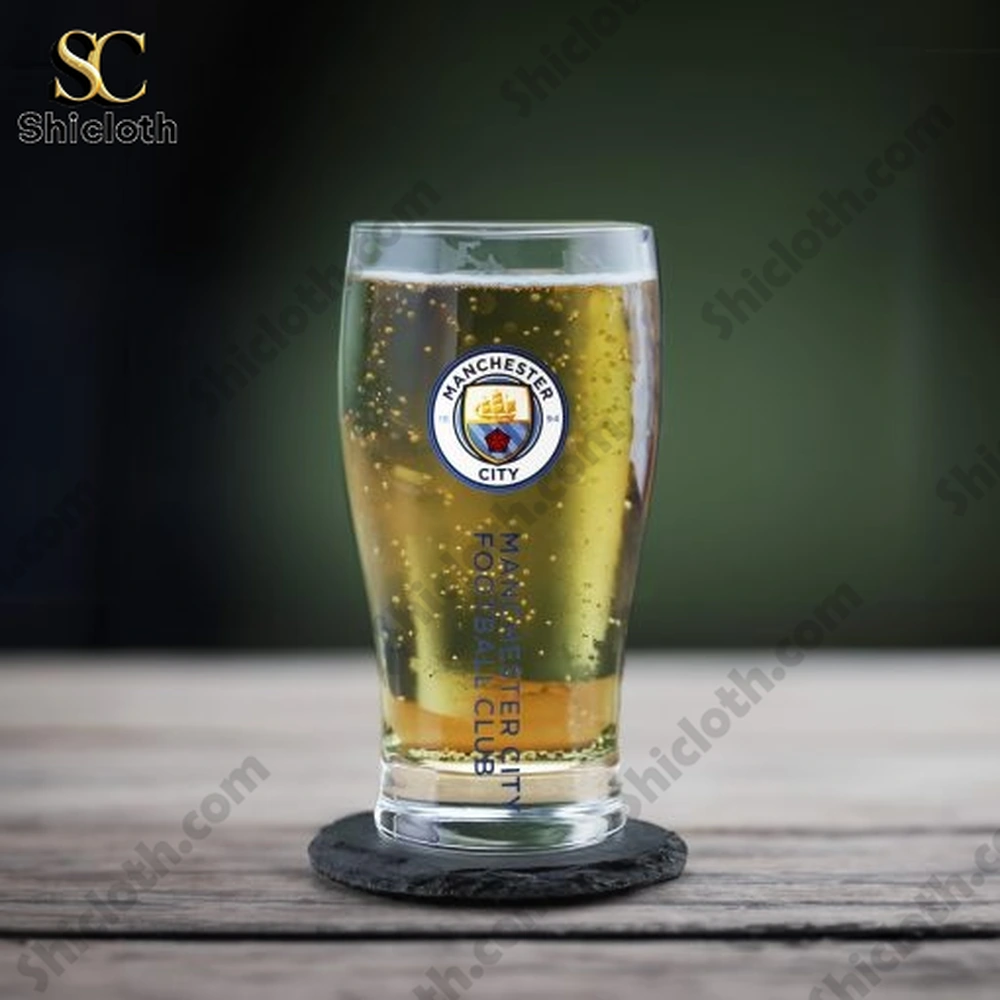 Manchester City whiskey glass filled with sparkling beer on table!