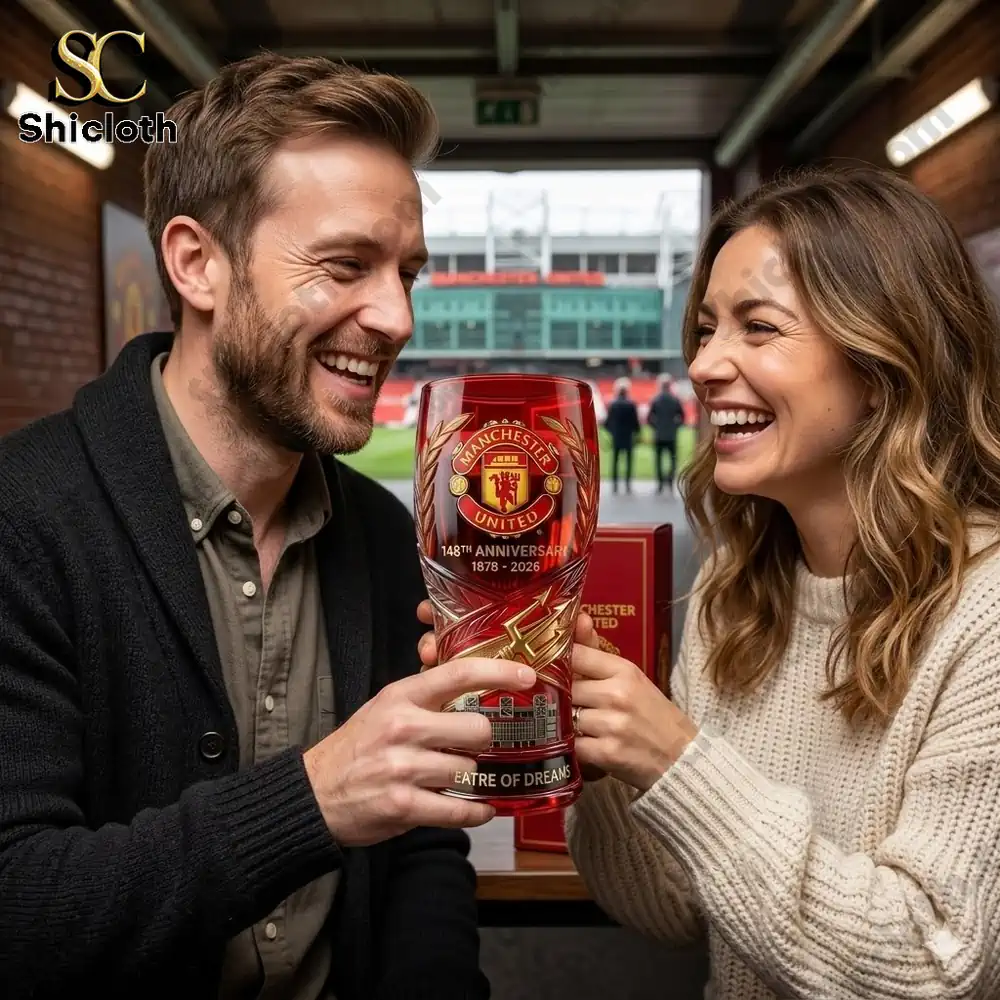 couple smiling while holding manchester united anniversary glass at stadium!