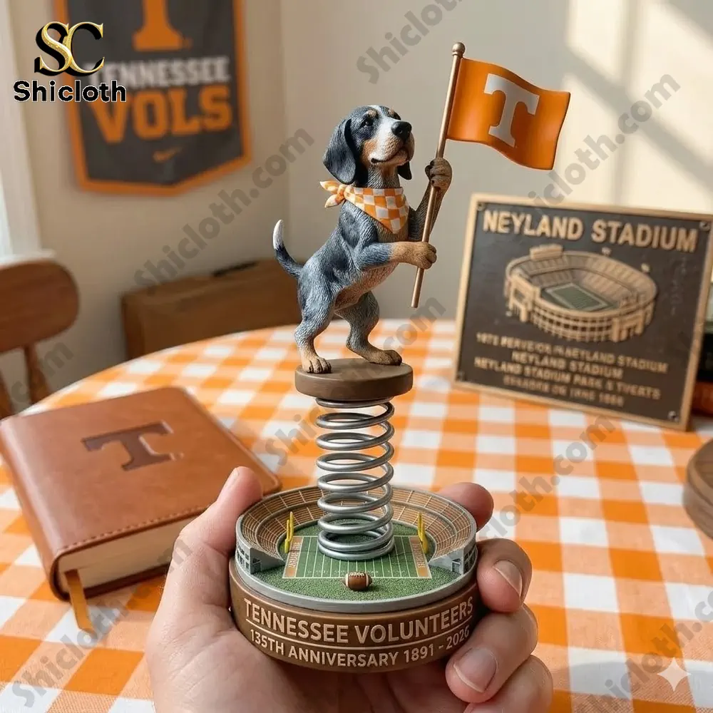 Dog bobblehead holding orange Tennessee flag on spring base football field style decor!