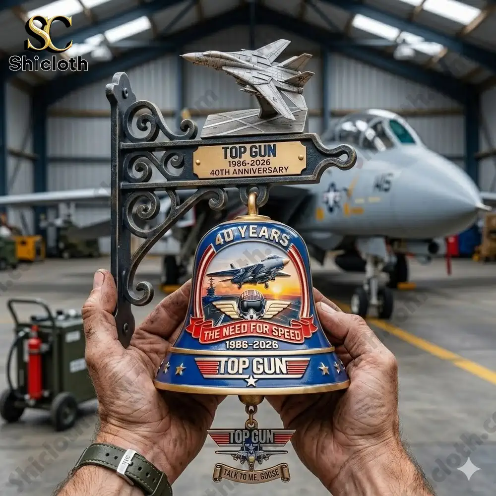 Top Gun anniversary wall bell with jet model held in hands inside aircraft hangar by Shicloth!