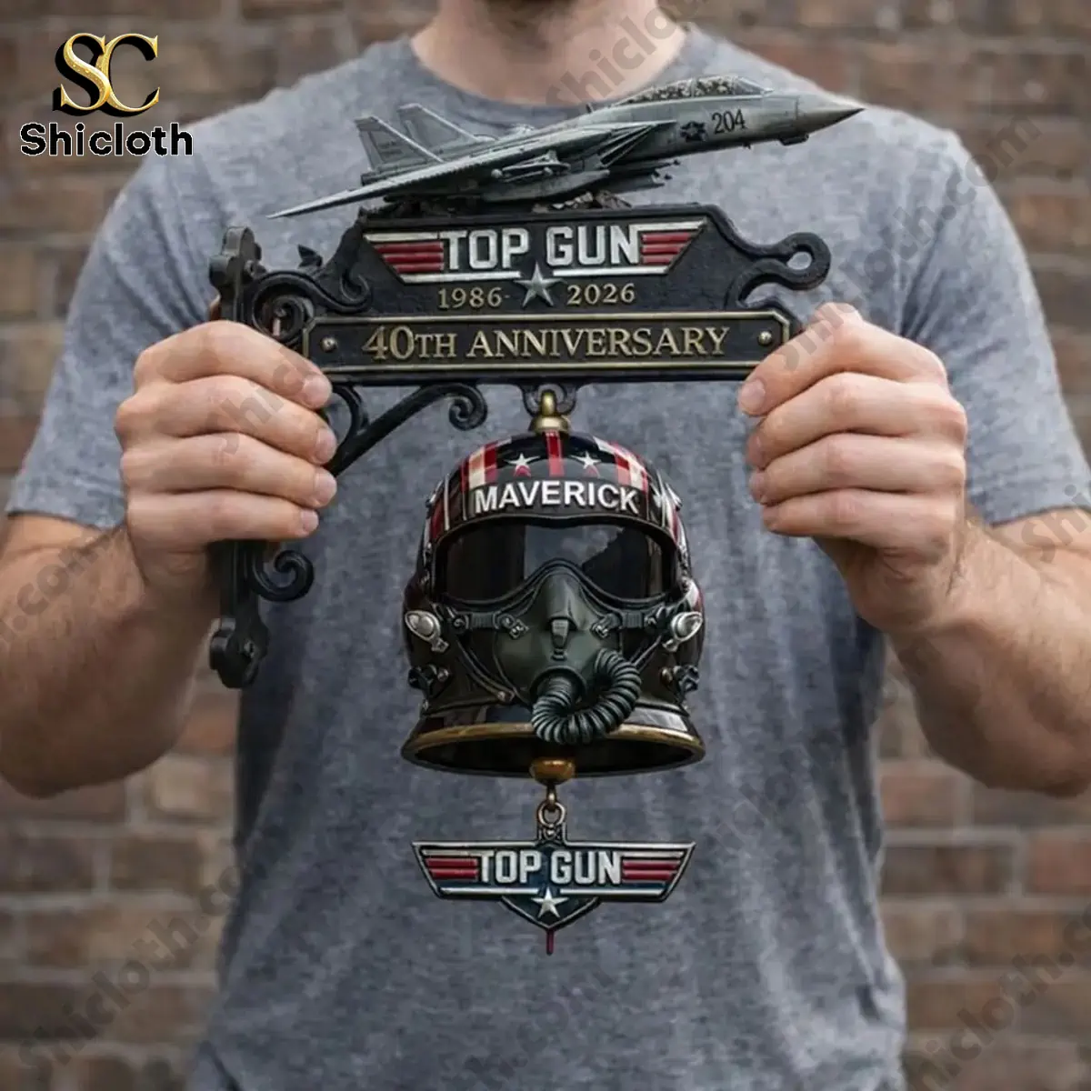 Man holding Top Gun 40th Anniversary Maverick wall bell with jet model and helmet design.