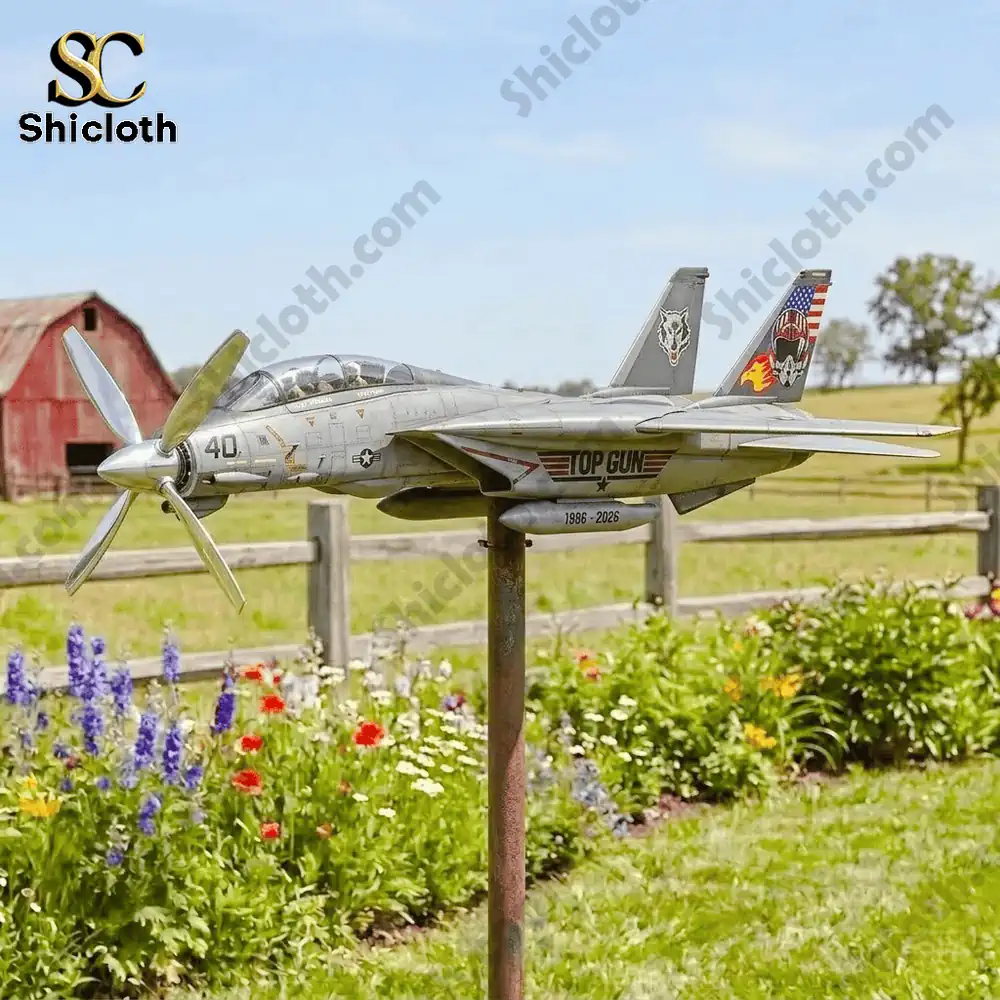 Airplane wind spinner on pole in a flower garden near a barn