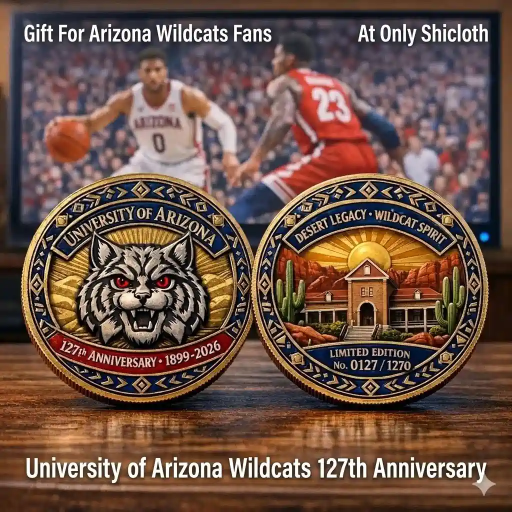 University of Arizona Wildcats 127th Anniversary commemorative coin front and back displayed on wooden table with basketball game in background.