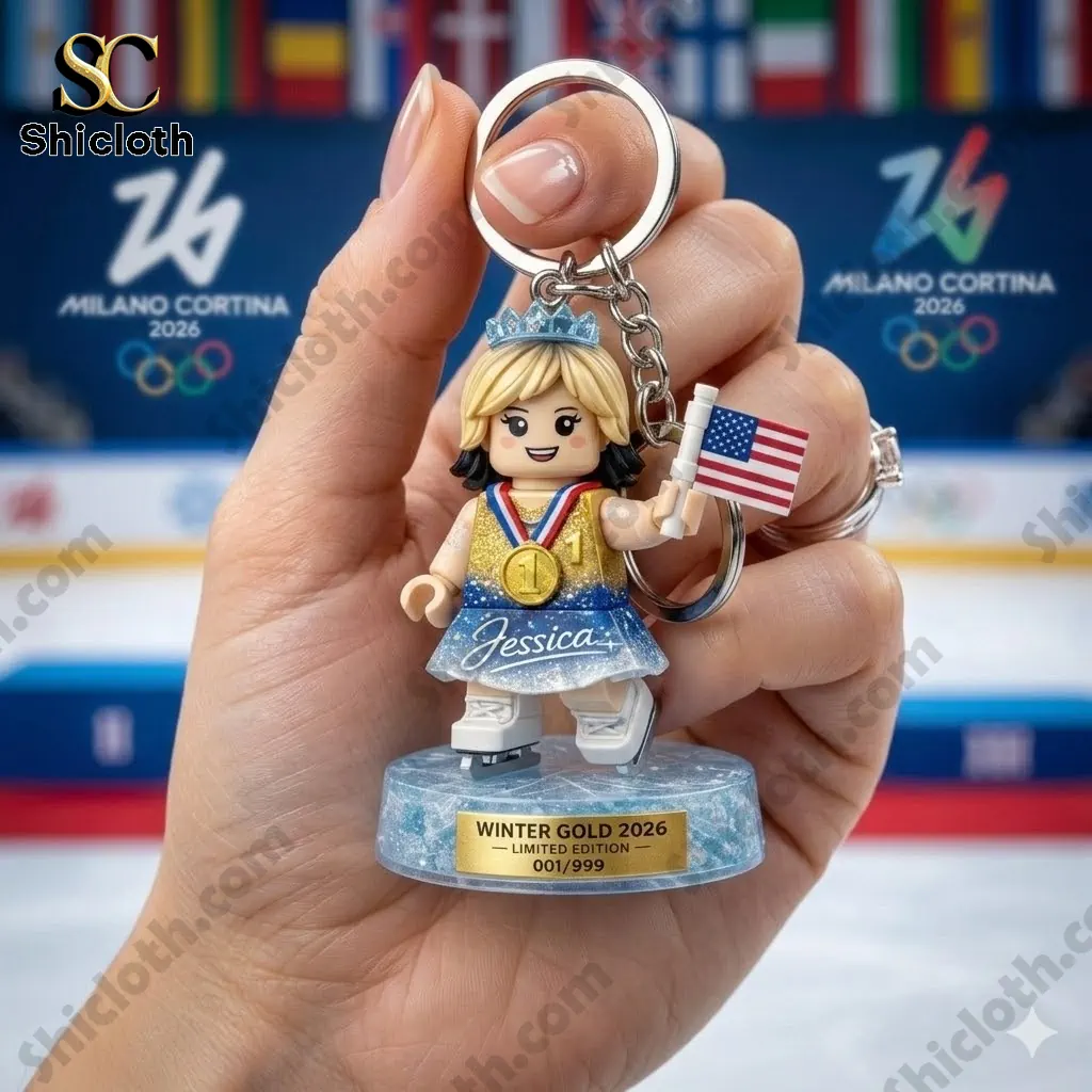Winter Gold 2026 Jessica champion skater keychain held in hand with Milano Cortina 2026 ice rink background.