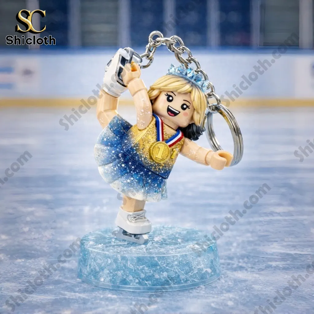 Winter Gold 2026 Jessica skater keychain performing a spin pose on an ice rink surface.