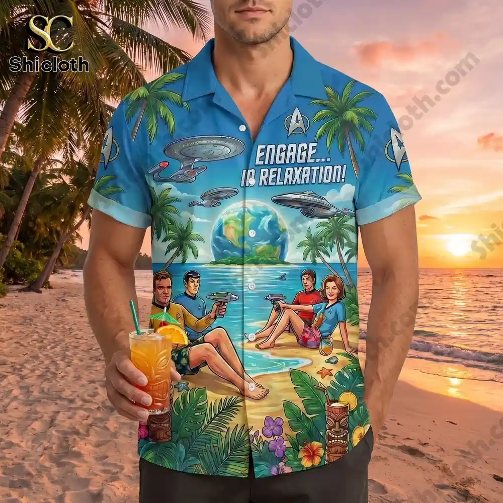 A man wearing the Star Trek Hawaiian shirt on a beach with a drink.