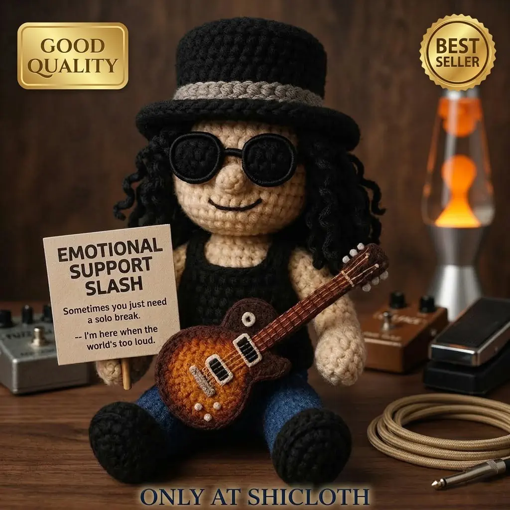 Handmade amigurumi doll of a rock star sitting on a wooden desk with music gear!