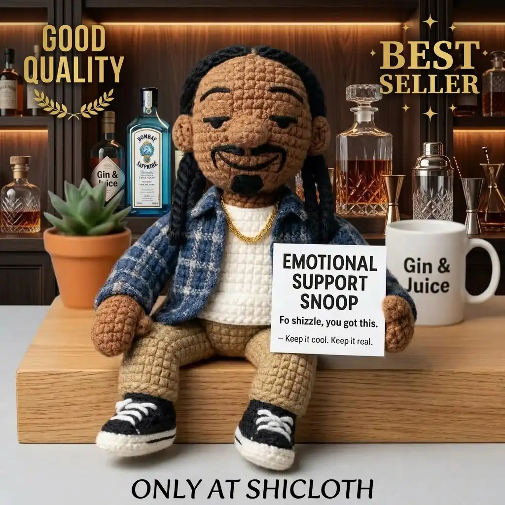A crochet rapper doll sitting on a wooden surface with bar accessories and a Gin and Juice mug!