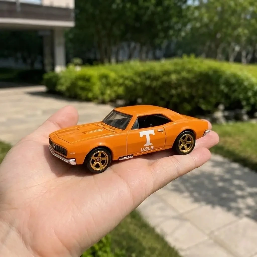 Hot Wheels Tennessee Vols 135th Anniversary Chevrolet Camaro 3 Hot Wheels Tennessee Vols 135th Anniversary Chevrolet Camaro held in a hand outdoors.