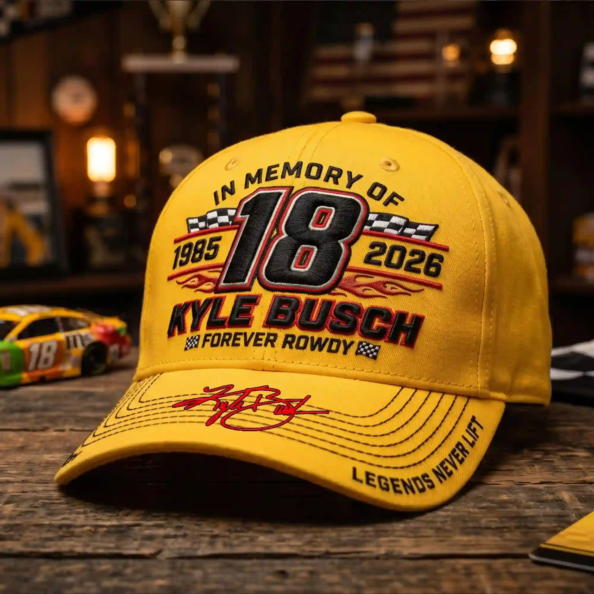In Memory Of Kyle Busch Forever Rowdy Legends Never Lift Limited Cap 6 Alt text Close-up of yellow Kyle Busch memorial cap style 3 showing number 18 and flames