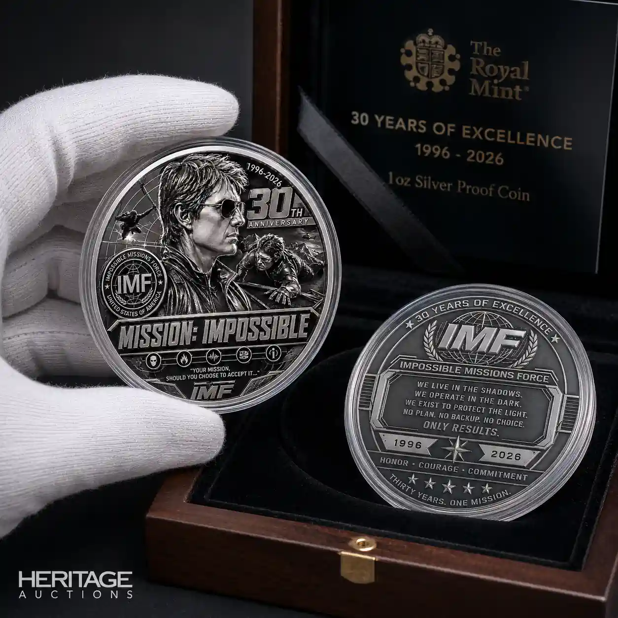 Two silver proof Mission Impossible anniversary coins are shown inside a luxury wooden display box held by a gloved hand!