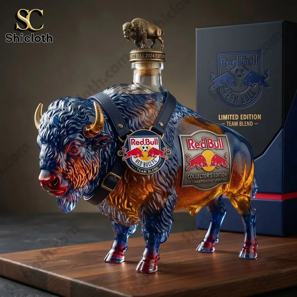A decorative Red Bull 2024 edition glass bottle shaped like a bison on a wooden surface